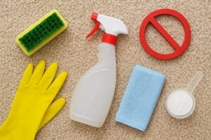 Hand brushing a wool carpet with gentle cleaner to prevent damage and maintain softness